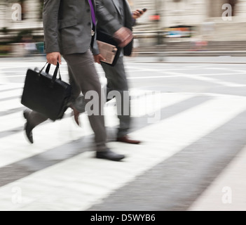 Businessman crossing city street Stock Photo