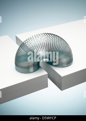 Metal slinky spanning space between blocks Stock Photo