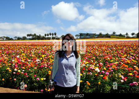 Young woman standing in front of the Ranunculus fields in Calrsbad Stock Photo