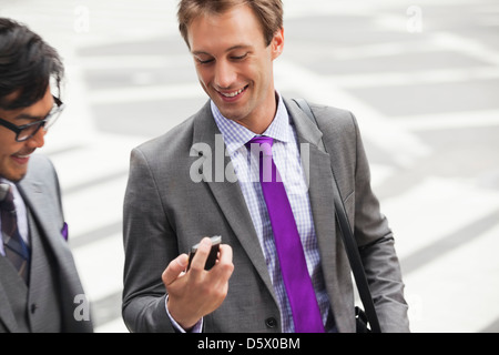 Businessmen talking on city street Stock Photo