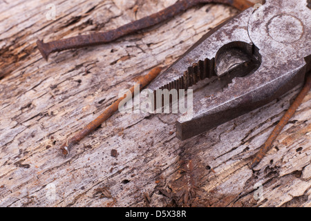 handmade nails with pliers on old background Stock Photo