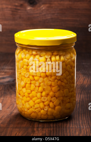 Sweet corn in glass jar on a wooden table Stock Photo