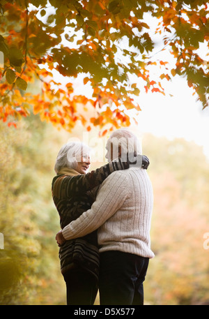 Older couple hugging in park Stock Photo
