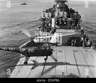 USS Manchester (CL-83) Sikorsky HO3S helicopter, of squadron HU-1, lands on the cruiser's after deck after a gunfire spotting mission off the Korean coast, March 1953.