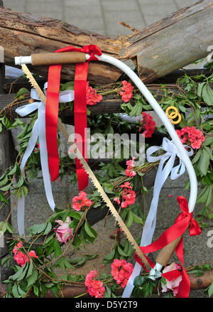 A saw hangs on a sawhorse holding a trunk of wood that the newly-weds have just sawed through after their wedding ceremony in Sieversdorf, Germany, 01 September 2012. Photo: Patrick Pleul Stock Photo