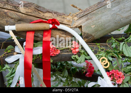 A saw hangs on a sawhorse holding a trunk of wood that the newly-weds have just sawed through after their wedding ceremony in Sieversdorf, Germany, 01 September 2012. Photo: Patrick Pleul Stock Photo