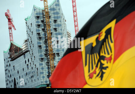 A German flag with the German Eagle flies in front of constrcution site of the Elbe Philharmonic Hall on the frigate 'Hamburg' at the harbor in Hamburg, Germany, 15 September 2012. Photo: Daniel Reinhardt Stock Photo