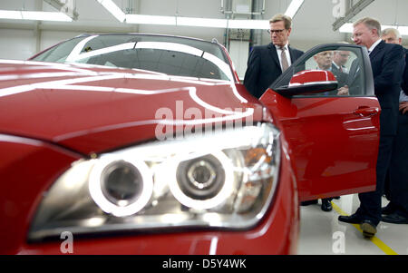 German Foreign Minister Guido Westerwelle (front-L) and board member of BMW AG, Frank-Peter Arndt (front-R) stand next to a BMW X1 at a production plant in Shenyang, China, 12 october 2012. Westerwelle is on a three-day visit to China. Photo: RAINER JENSEN Stock Photo