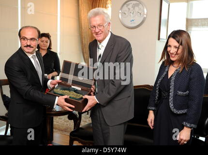 Der baden-württembergische Ministerpräsident Winfried Kretschmann (M, Bündnis 90/Die Grünen) bekommt am 15.10.2012 in Ankara (Türkei) vom Präsidenten des Amtes für Auslandstürken, Kemal Yurtnac (l), ein Gastgeschenk. Rechts die baden-württembergische Integrationsministerin Bilkay Öney. Der baden-württembergische Regierungschef ist mit einer 80-köpfigen Delegation aus Politik, Wirts Stock Photo