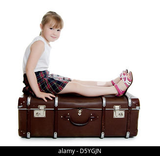 The little girl on old suitcases Stock Photo