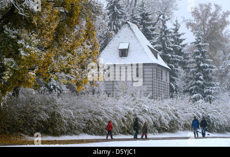 People walk past Goethe's garden house in the snow in Weimar, Germany, 27 October 2012. Winter has come to Germany early this season. Photo: Hendrik Schmidt
