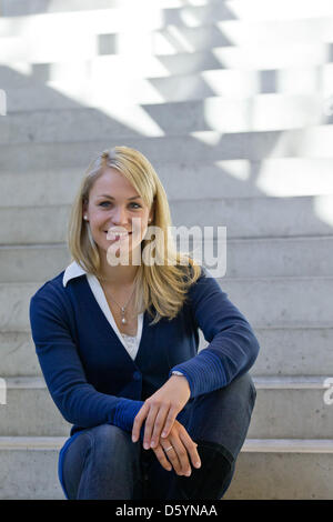 Former biathlete Magdalena Neuner sits on a stair during the official outfitting of the German Ski Association (DSV) in Herzogenaurach, Germany, 31 October 2012. Photo: Daniel Karmann Stock Photo