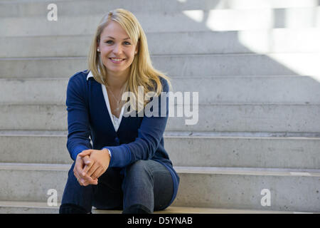 Former biathlete Magdalena Neuner sits on a stair during the official outfitting of the German Ski Association (DSV) in Herzogenaurach, Germany, 31 October 2012. Photo: Daniel Karmann Stock Photo