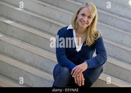 Former biathlete Magdalena Neuner sits on a stair during the official outfitting of the German Ski Association (DSV) in Herzogenaurach, Germany, 31 October 2012. Photo: Daniel Karmann Stock Photo