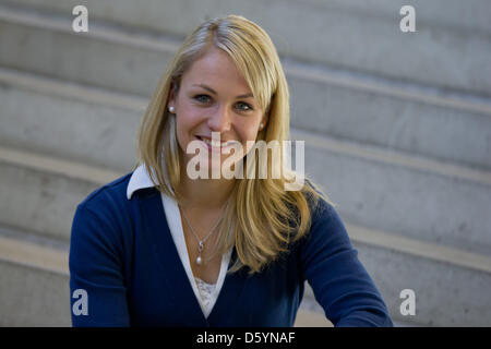 Former biathlete Magdalena Neuner sits on a stair during the official outfitting of the German Ski Association (DSV) in Herzogenaurach, Germany, 31 October 2012. Photo: Daniel Karmann Stock Photo