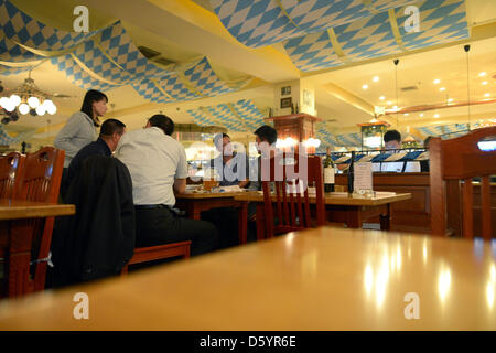 People sit at the restaurant and bar 'Paulander Munich' in a hotel in Shenyang, China, 13 October 2012. Photo: Rainer Jensen Stock Photo