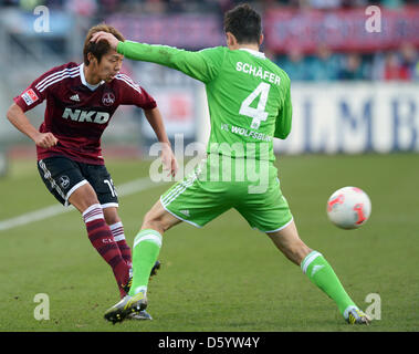 Nuremberg's Hiroshi Kiyotake (l) plays the ball past Wolfsburg's Marcel Schaefer during a German Bundesliga match between 1 FC Nuremberg and VfL Wolfsburg at easyCredit stadium in Nuermberg, Germany, 3 November 2012. Photo: DAVID EBENER    (ATTENTION: EMBARGO CONDITIONS! The DFL permits the further utilisation of up to 15 pictures only (no sequntial pictures or video-similar series Stock Photo