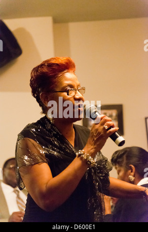 Woman singing for lunch-time diners in Silvia's Restaurant where they serve soul food. Stock Photo