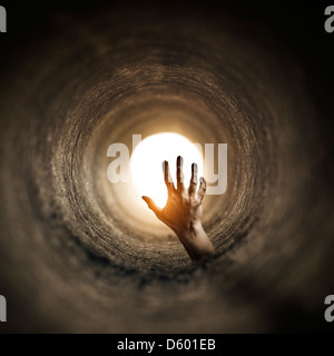 Tunnel Horror. Zombified hand rising up inside a dark tunnel... Stock Photo