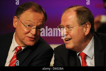 The SPD top candidate for the upcoming state parliament election in Lower Saxony, Stephan Weil (l), greets the designated SPD chancellery candidate Peer Steinbrueck (m) during the state party meeting of the Lower Saxonian Social Democrats in Wolfsburg, Germany, 10 November 2012. Two months before the elections, the party will agree on their electoral program. Photo: JOCHEN LUEBKE Stock Photo