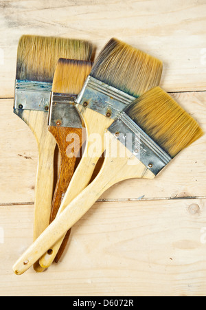 Old paint brushes on wooden background Stock Photo