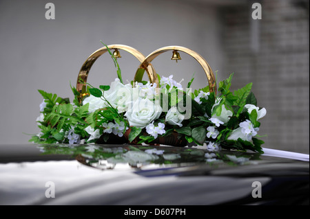 Wedding rings and bunch of flowers on the black car Stock Photo