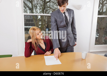 Young businesspeople reviewing documents t conference table Stock Photo