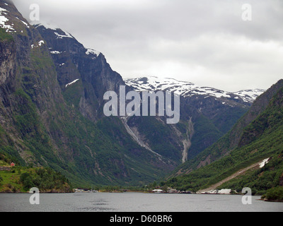 The town of Gudvangen dwarfed by the towering peaks over the Naerfjorden,Norway Stock Photo