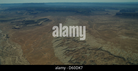 Aerial arid landscape view, to Oljato Mesa, dry braided stream channel passing eroded slope white rock, Piute Farms Wash, Utah Stock Photo