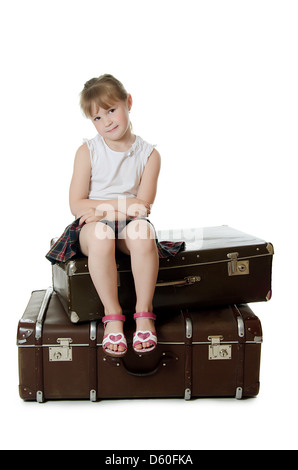 The little girl on old suitcases Stock Photo