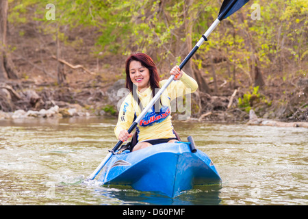 Kayaking on the Frio River, Texas, USA - Young Hispanic woman of 18 riding a kayak Stock Photo