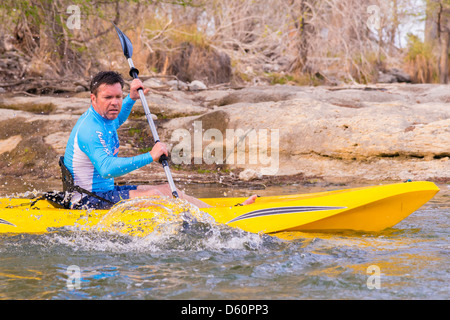 Middle-aged man riding a kayak for recreation on the Frio River, Texas, USA Stock Photo