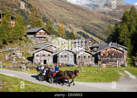 The alp Aussergschloess in East Tyrol, national park Hohe Tauern, with tourists in a horse drawn carriage. East Tyrol, Austria. Stock Photo