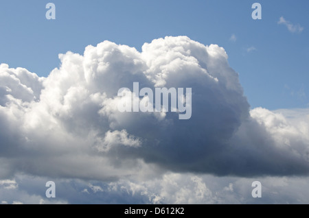 A big, fluffy white cumulus cloud in a blue sky. Stock Photo