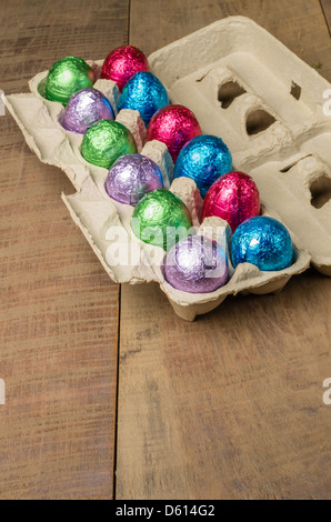 Colorful foiled chocolate eggs in egg container Stock Photo
