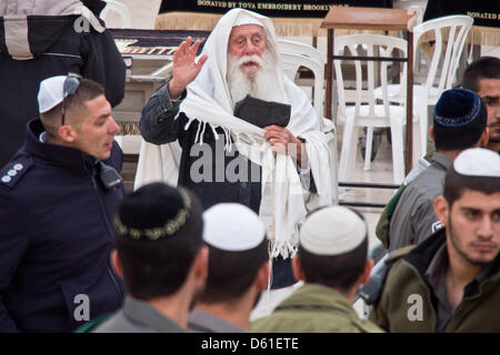 Jerusalem, Israel. 11th April 2013. Orthodox Jewish men protest the practices of Women of The Wall as they wear prayer shawls and phylacteries, pray and sing out loud, in defiance of Orthodox Jewish tradition and court rulings against these practices. Jerusalem, Israel. 11-April-2013.  Five women detained at Western Wall for donning prayer shawls and phylacteries in defiance of Orthodox Jewish monopoly reserving these practices for men, a ruling Women of The Wall have been battling, demanding egalitarian practice of Judaism. Credit: Nir Alon / Alamy Live News Stock Photo