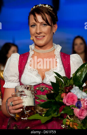 Barbara Hostmann poses with a glas of beer on stage after being voted 'Bavaria's Beer Queen' at Augustiner Keller in Munich, Germany, 19 April 2012. 21-year-old Hostmann was selected to be the new Bavarian Beer Queen by a jury and votes of the audience. Photo: Sven Hoppe Stock Photo