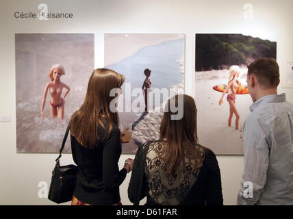 Visitors observe art pieces at the  'Affordable Art Fair' in New York, USA, 18 APril 2012. The fair features 40 US artists and about 35 international artists and shall offer visitors a mix of art, education and fun, according to the organisers. Visitors shall be animalted to collect art themselves and therefore none of the pieces exhibited cost more than 10 000 dollars. Photo: Chri Stock Photo