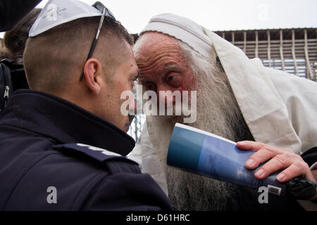 Jerusalem, Israel. 11th April 2013. Orthodox Jewish men protest the practices of Women of The Wall as they wear prayer shawls and phylacteries, pray and sing out loud, in defiance of Orthodox Jewish tradition and court rulings against these practices. Jerusalem, Israel. 11-April-2013.  Five women detained at Western Wall for donning prayer shawls and phylacteries in defiance of Orthodox Jewish monopoly reserving these practices for men, a ruling Women of The Wall have been battling, demanding egalitarian practice of Judaism. Credit: Nir Alon / Alamy Live News Stock Photo