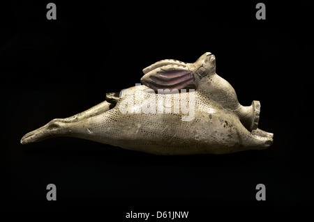 An ancient Etruscan-Corinthian ceramic perfume bottle in the form of a reclining hare, dating from circa 540 BC, isolated against a solid black background Stock Photo