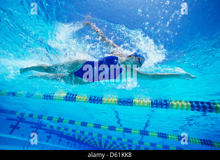 Female swimmer wearing United States swimsuit while swimming in pool Stock Photo