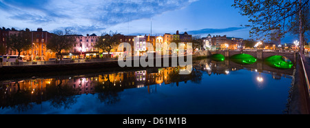 Horizontal panoramic view of the O'Connell Bridge or Droichead Uí Chonaill crossing the River Liffey in Dublin at night. Stock Photo