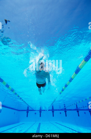 Underwater shot of young male thlete doing backstroke in swimming pool Stock Photo