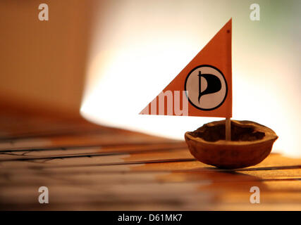 (dpa FILE) - An archive picture, dated 5 January 2012, shows a nutshell with a miniature banneret placed on a table at the party office in Kiel, Germany. The Pirate Party will hold ist party conference in Nuemuenster on 28 April and 29 April 2012. Photo: Bodo Marks Stock Photo