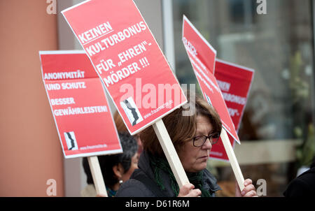 A demonstrator holds a placard saying 'Keinen Kulturbonus für 'Ehren'moerder !!!' ('No cultural bonus for 'honour' killers') in front of the Regional Court in Detmold, Germany, 30 April 2012. Five siblilngs of the kidnapped and killed Kurd Arzu O. have to stand trial this morning, three of them in prosecution of murder. Four brothers and one sister of 18 year old Arzu are accused o Stock Photo