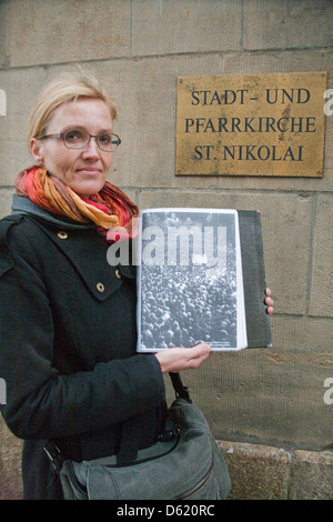 Leipzig, Germany. Tourist guide displays plaque on outer wall of St. Nicholas Church honoring German Unification Movement. (MR) Stock Photo