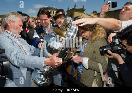 Former Bayern Munich soccer players Paul Breitner (L) presents the UEFA Champions League Cup during a Champions League Cup bus tour in Munich, Germany, 14 May 2012. The Champions League final match between FC Bayern Munich and Chelsea FC will take place on 19 May 2012. Photo: PETER KNEFFEL Stock Photo