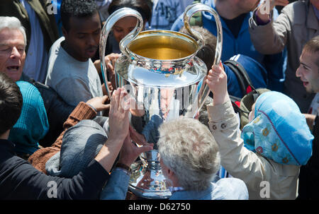 Former Bayern Munich soccer players Paul Breitner (bottom, blue jacket) presents the UEFA Champions League Cup during a Champions League Cup bus tour in Munich, Germany, 14 May 2012. The Champions League final match between FC Bayern Munich and Chelsea FC will take place on 19 May 2012. Photo: PETER KNEFFEL Stock Photo