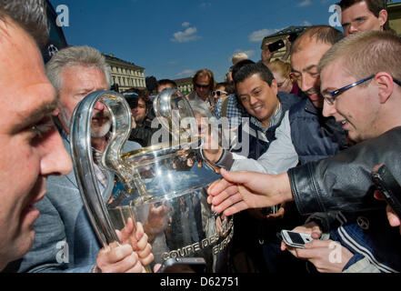 Former Bayern Munich soccer players Paul Breitner (L) presents the UEFA Champions League Cup during a Champions League Cup bus tour in Munich, Germany, 14 May 2012. The Champions League final match between FC Bayern Munich and Chelsea FC will take place on 19 May 2012. Photo: PETER KNEFFEL Stock Photo