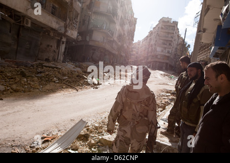 Aleppo, Syria. A ruined street on the front lines in Aleppo. Fighters stand to the side out of a snipers view. Stock Photo